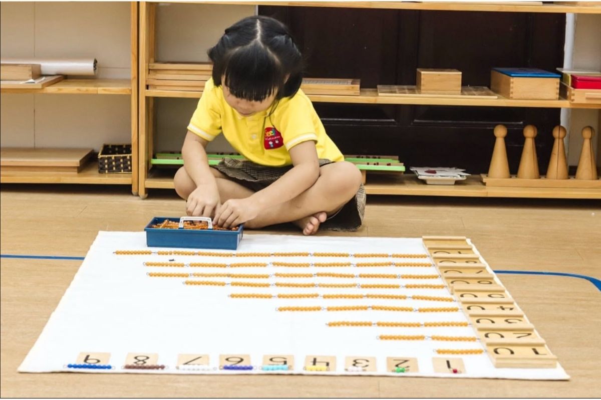 Young child using concrete Montessori-informed materials for matching, counting, quantity and number readiness