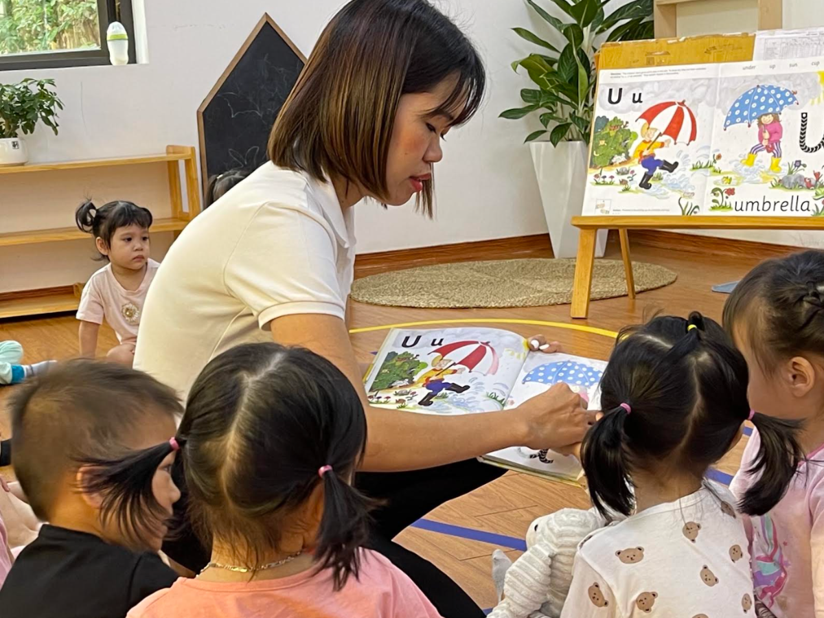 Filipino parent and young child sharing a reading and language activity with a piggy-bank learning metaphor