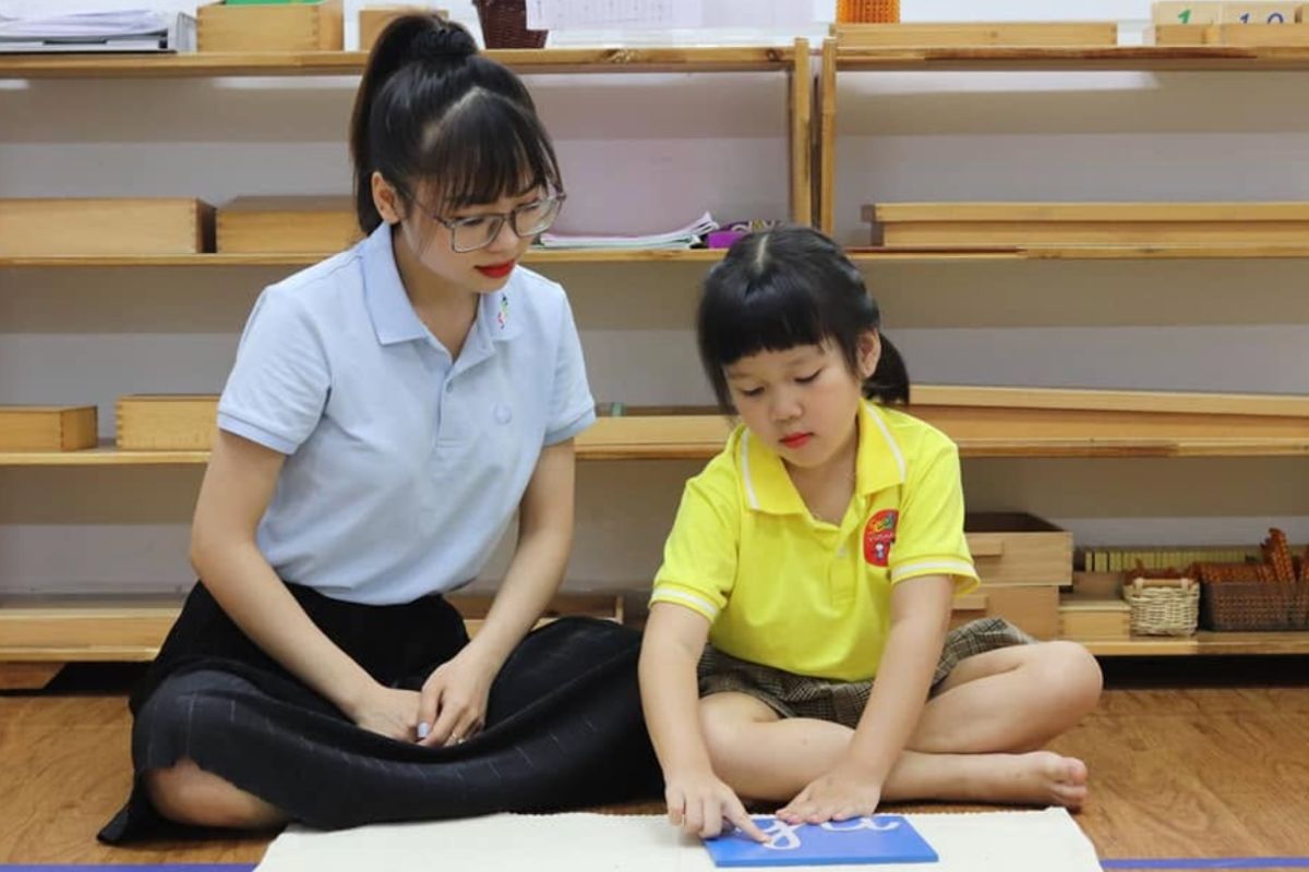 Young child and adult working with sensorial or language materials in a prepared environment