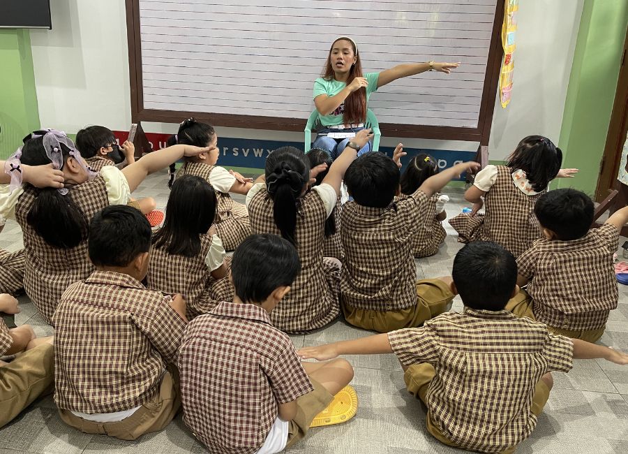 Teacher guiding young English learners through an active online lesson